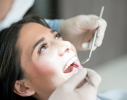 woman having her teeth cleaned at a dental office