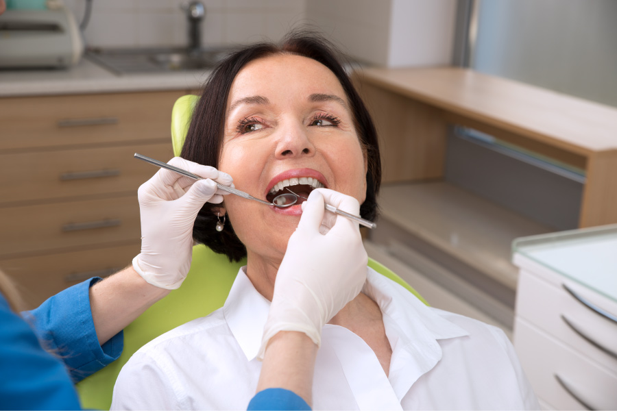 Brunette woman is receiving a dental cleaning & checkup at her dentist in Fayetteville, AR