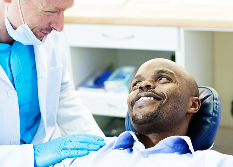 man being comforted by his dentist