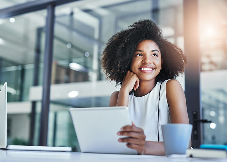 smiling woman sitting in front of a laptop