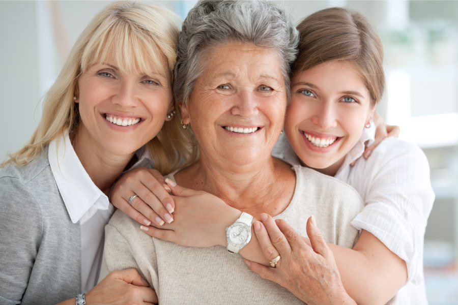 Mom, grandma, and daughter smile together