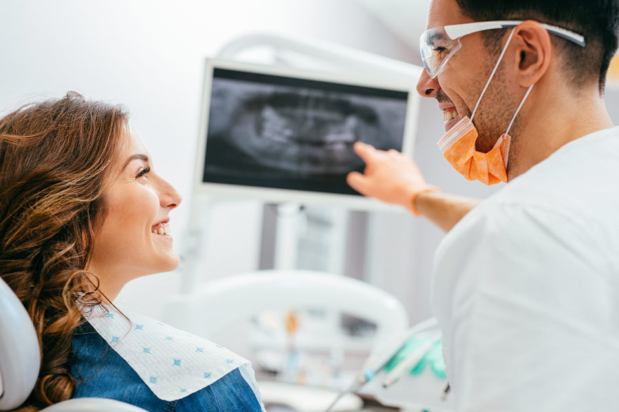 woman looks at her teeth's X-ray with the dentist