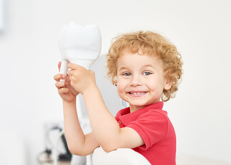 young boy with toy tooth